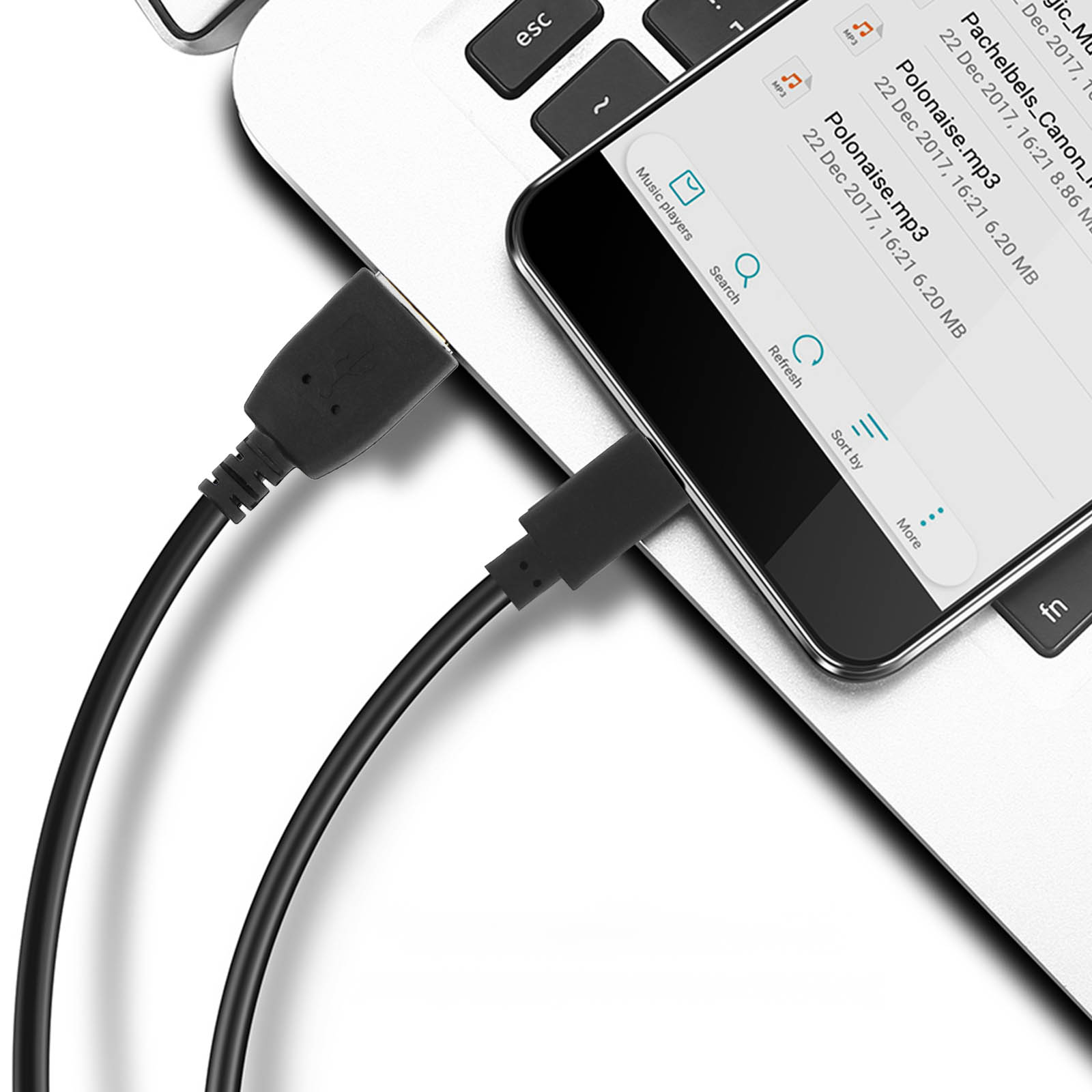 Un laptop con un telefono e cavi USB collegati. Il telefono mostra file musicali. Tasti della tastiera e superficie bianca visibili.