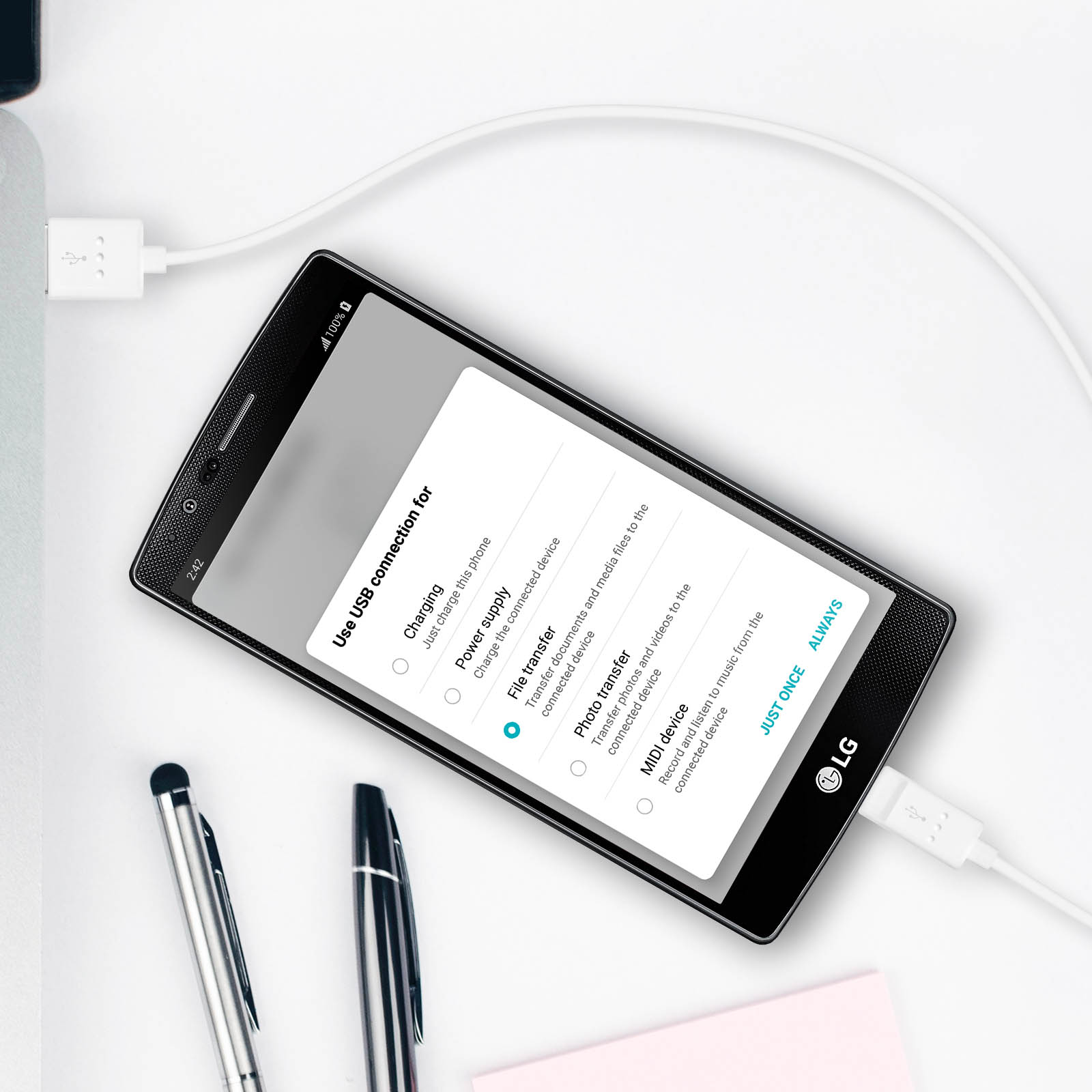Un telefono LG nero si sta caricando tramite USB. Lo schermo mostra le opzioni di connessione USB: ricarica, trasferimento file, trasferimento foto.