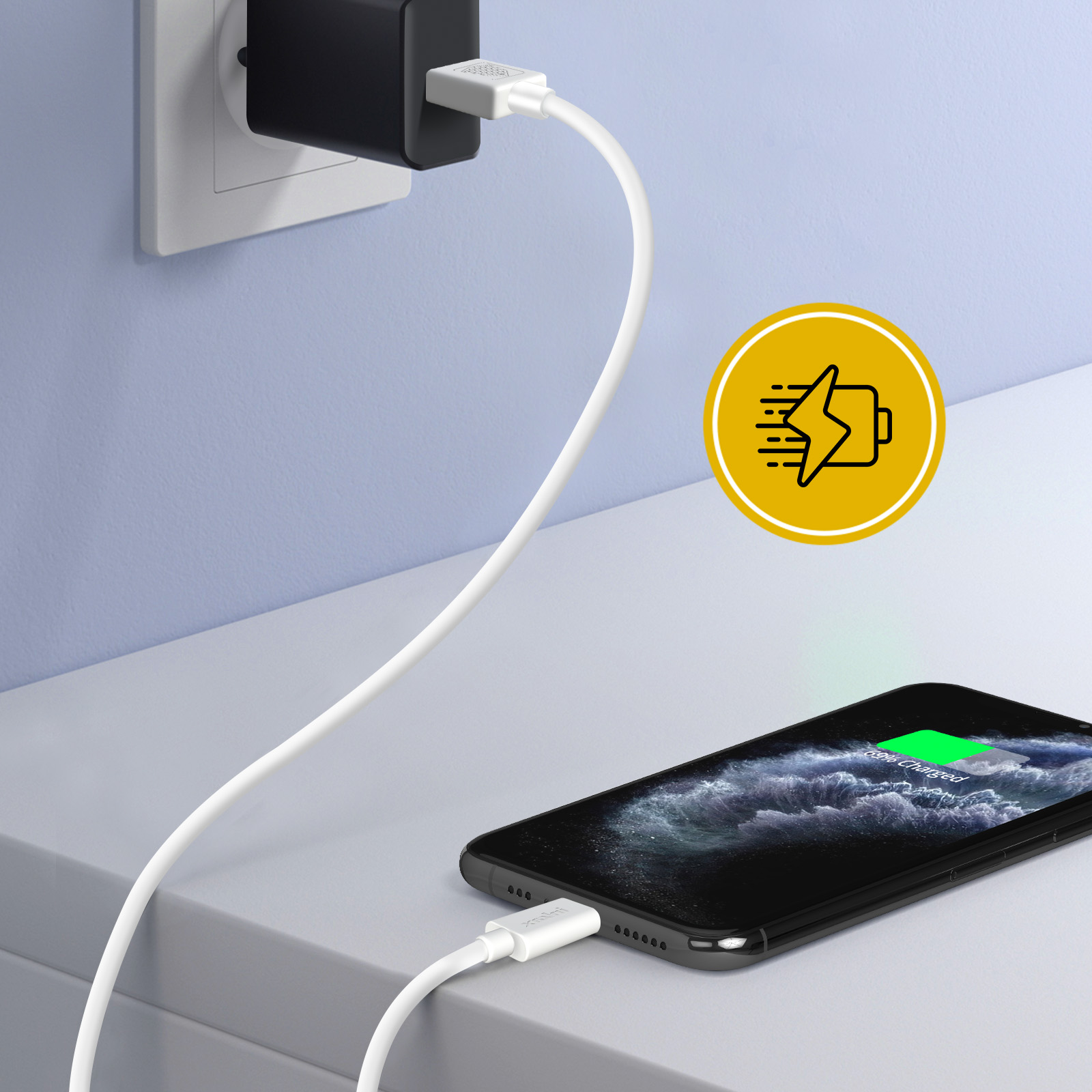 Un téléphone est en charge. Un câble blanc relie le téléphone à un chargeur noir branché au mur. Une icône de chargement est présente.