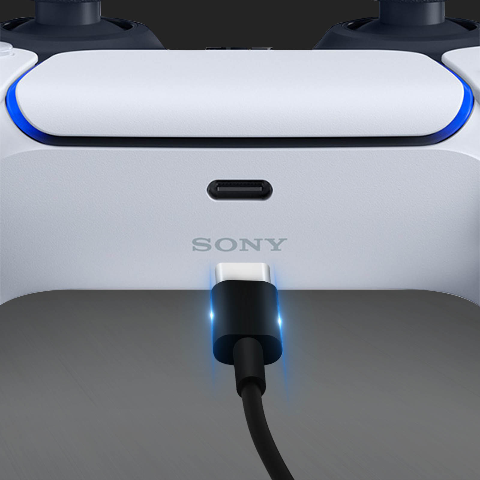 Un controller Sony PlayStation bianco si carica con un cavo USB-C nero. Il logo Sony è visibile.