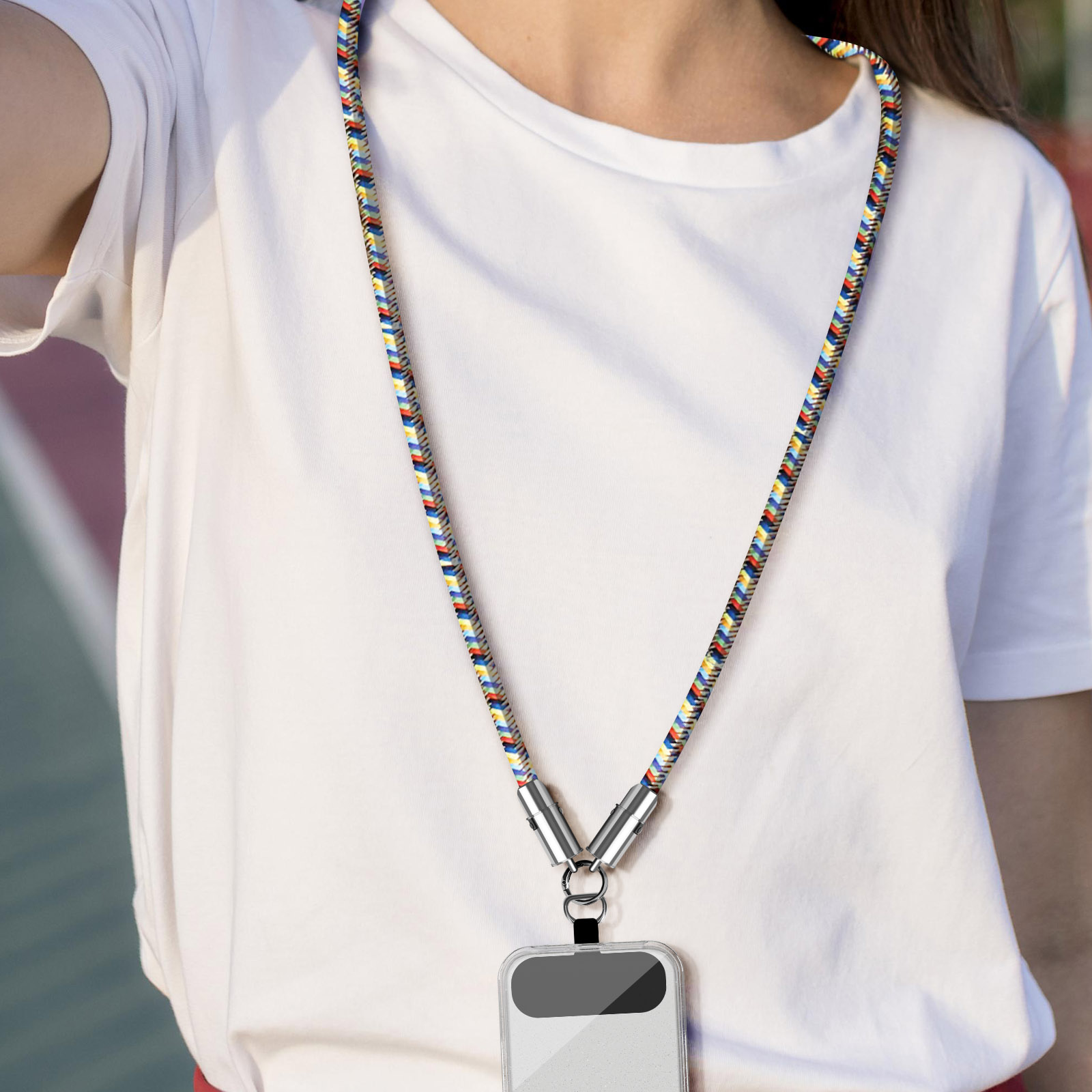 Eine Person trägt ein weißes Hemd mit einem bunten Lanyard, an dem ein Telefon befestigt ist. Das Lanyard hat einen silbernen Verschluss.