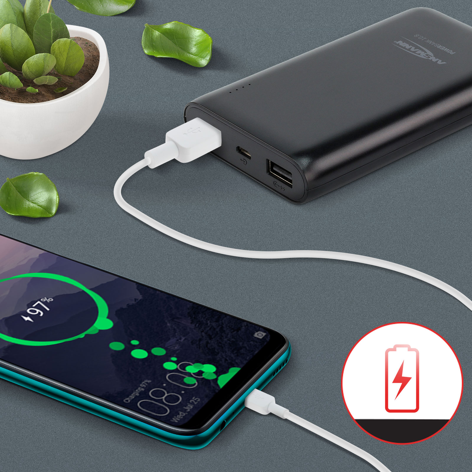 Un teléfono cargando desde un banco de energía. El teléfono muestra un 97% de carga. Hojas verdes y una maceta pequeña en el fondo.