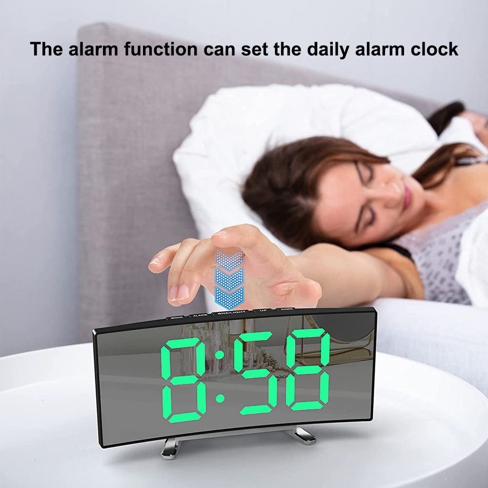Eine Digitaluhr zeigt 8:58. Eine Frau liegt im Bett. Eine Hand justiert die Uhr.