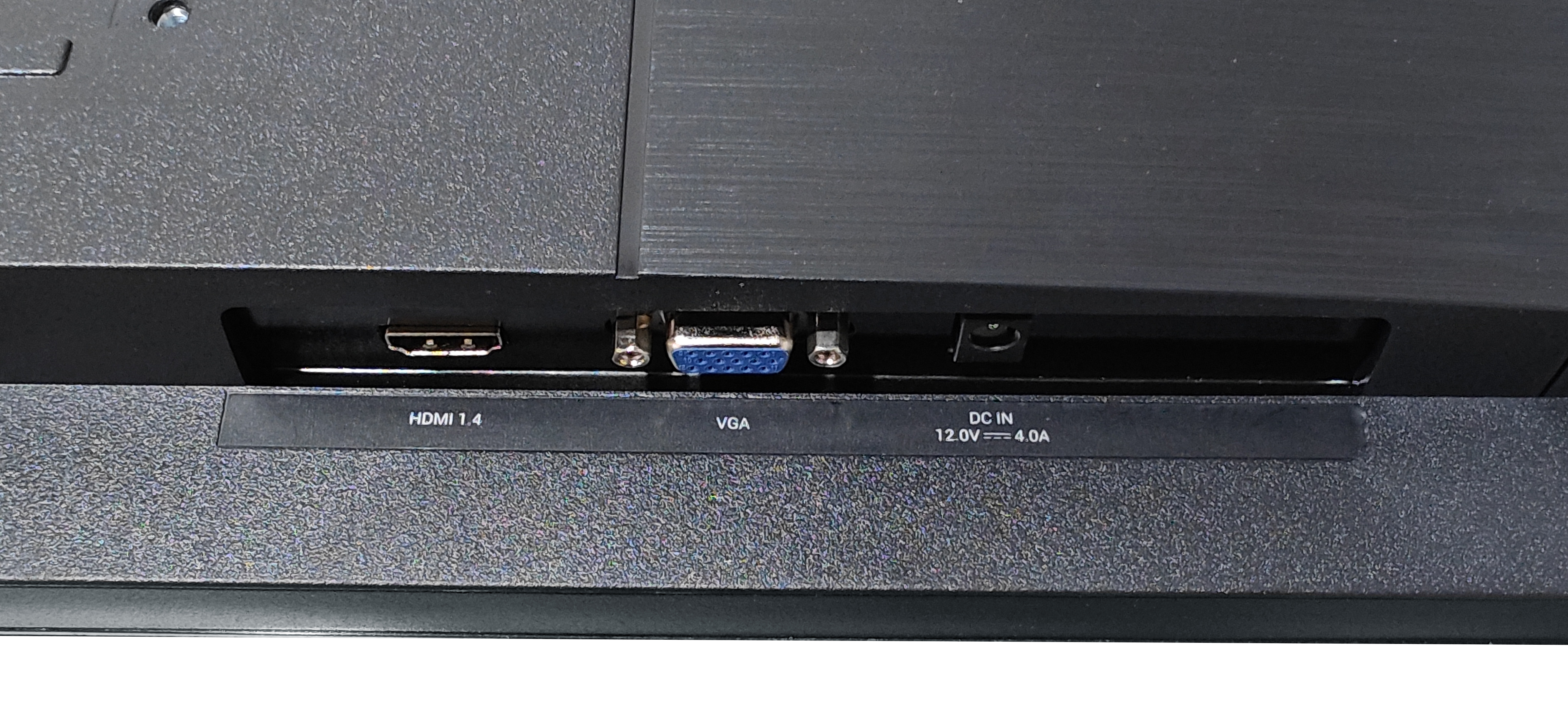 Primo piano del pannello posteriore di un monitor. Mostra porte HDMI, VGA e DC IN con etichette. Il pannello è nero.