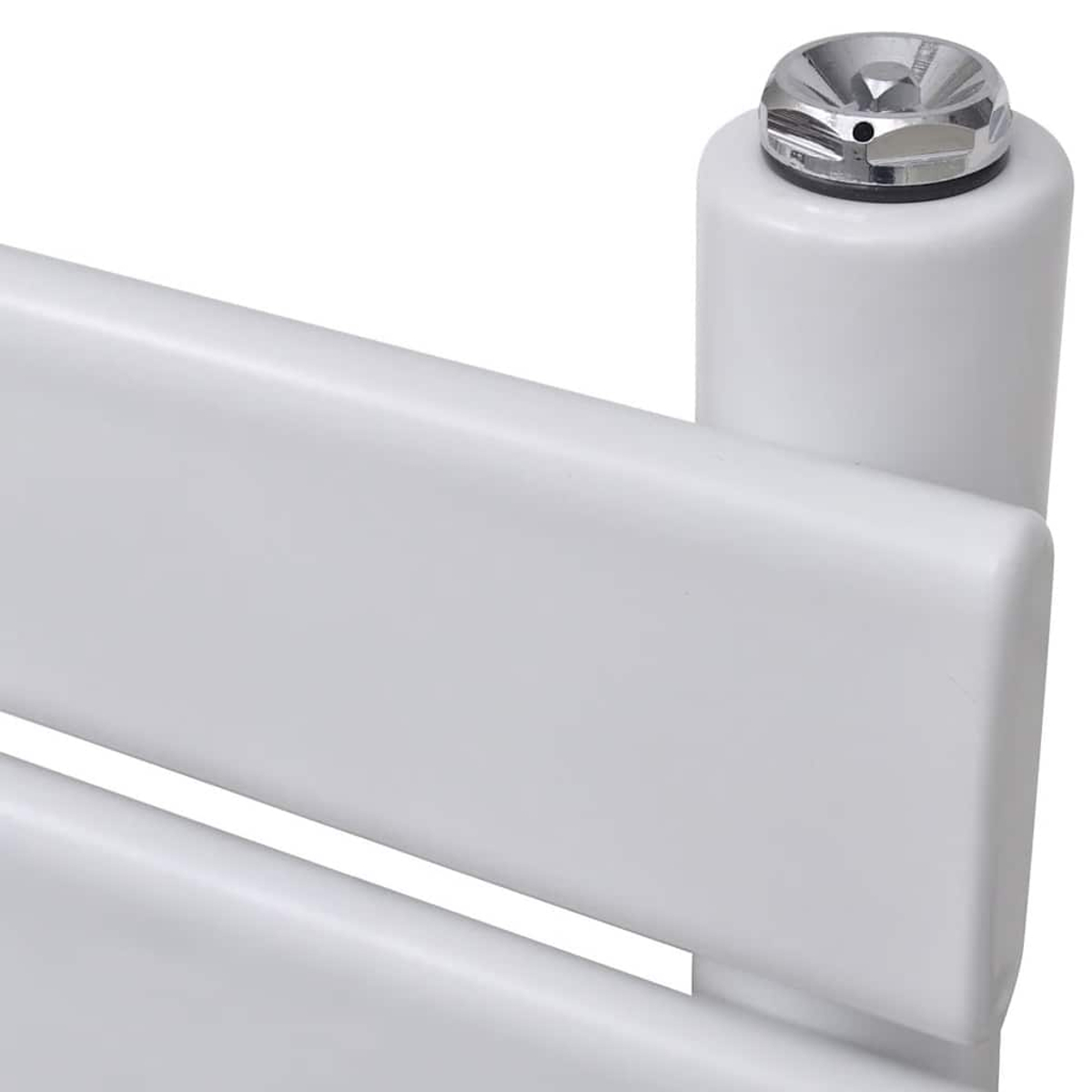Primo piano di un oggetto bianco con bordo arrotondato, un piccolo pezzo di metallo argentato sopra e un altro cilindro bianco.