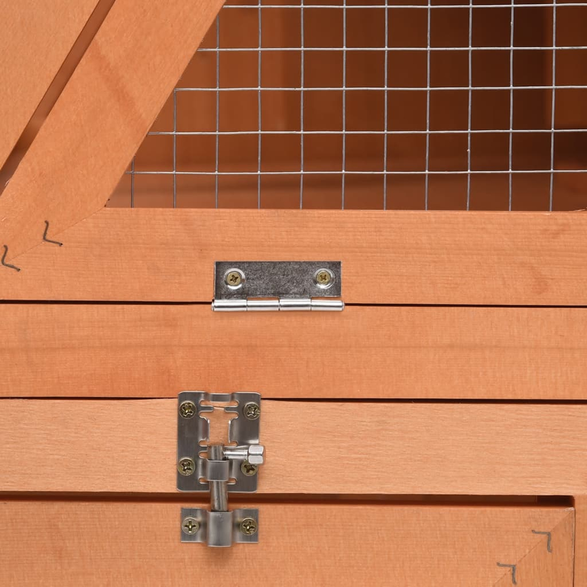Nahaufnahme eines hölzernen Käfigs mit Drahtgitter oben. Metallscharniere und ein Verschluss sind an der Holztür zu sehen. Das Holz ist hellbraun.