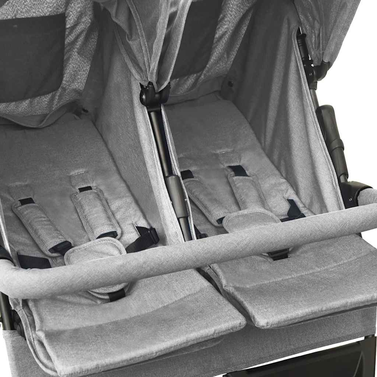 Ein grauer Zwillingskinderwagen mit zwei Sitzen, Sicherheitsgurten und einem Verdeck. Der Wagen hat eine Frontstange.
