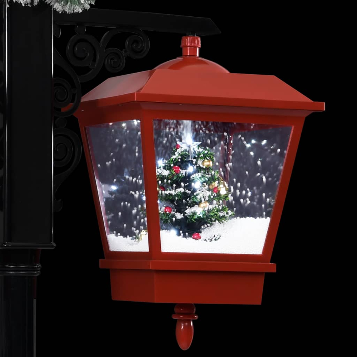 Rote Weihnachtslaterne mit Baum, Schneeeffekt, schwarze Stange mit Verzierungen, schwarzer Hintergrund.