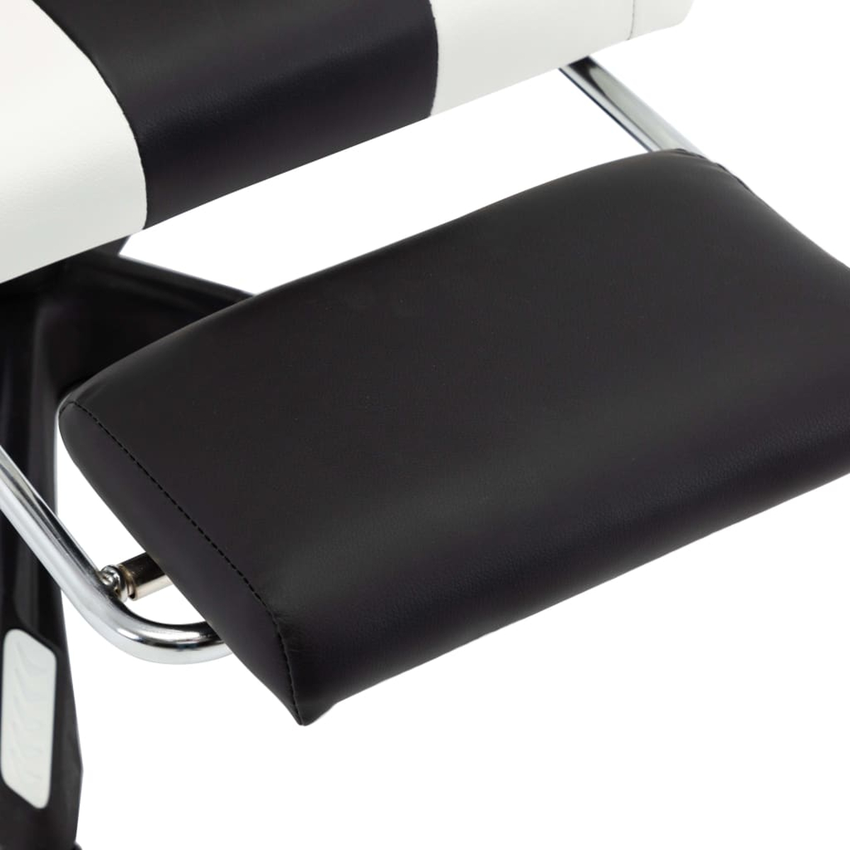 Nahaufnahme eines schwarz-weißen Friseurstuhls. Die Fußstütze ist aus schwarzem Leder, der Stuhl hat eine Chromstütze und weißes Leder.