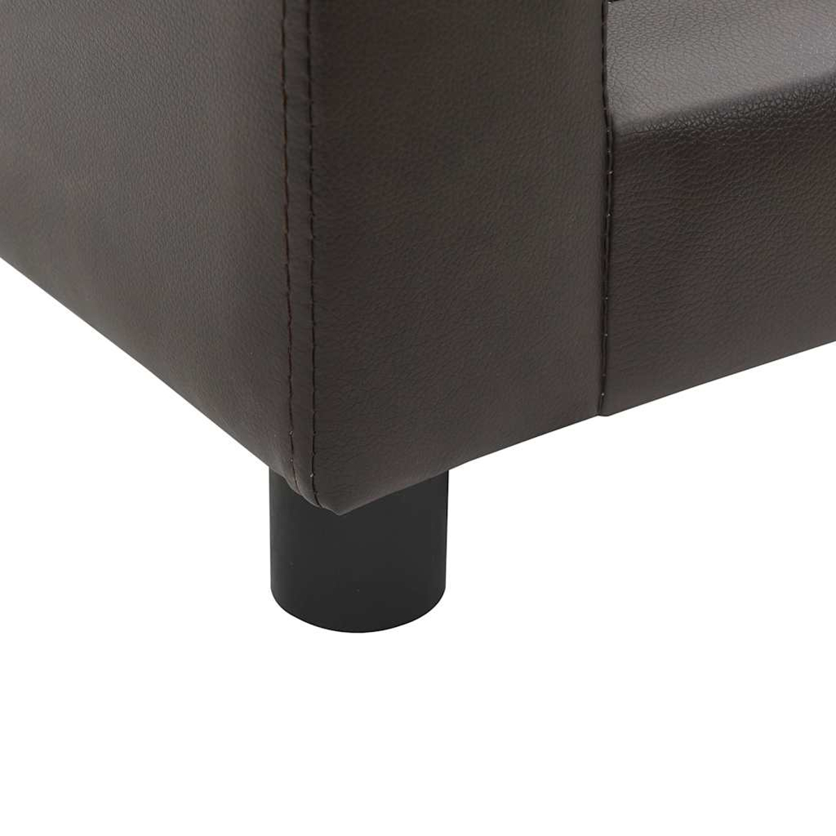 Nahaufnahme einer braunen Ledereckcouch. Ein schwarzes zylindrisches Bein stützt die Couch. Die Nähte sind an der Ecke sichtbar.