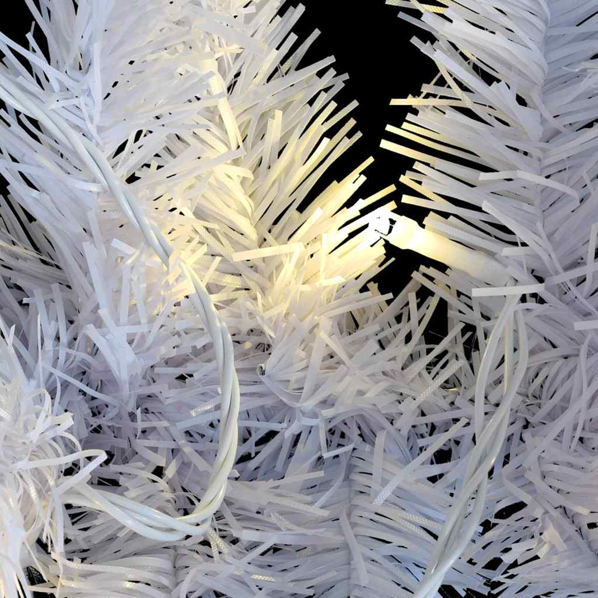 Nahaufnahme eines weißen Weihnachtsbaums mit Lichtern und schwarzem Hintergrund. Der Baum besteht aus weißen papierartigen Streifen. Licht scheint.