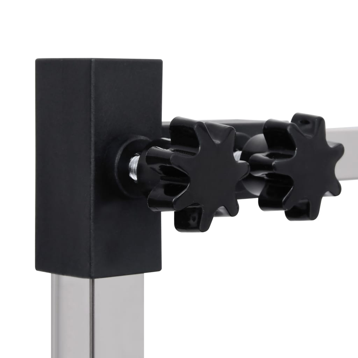 Nahaufnahme einer schwarzen, quadratischen Struktur, die mit einer Metallstange verbunden ist. Zwei schwarze, sternförmige Knöpfe sind rechts zu sehen.