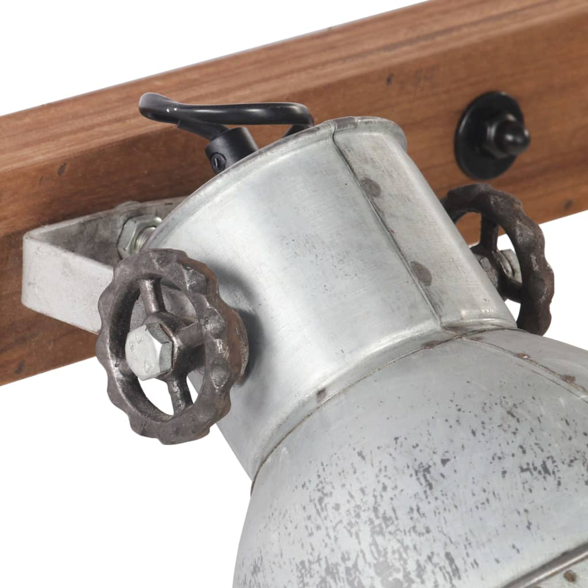 Ein Metall-Spotlight mit rostiger Oberfläche ist an einem Holzbalken befestigt. Es hat einen Griff und ein dekoratives Rad.