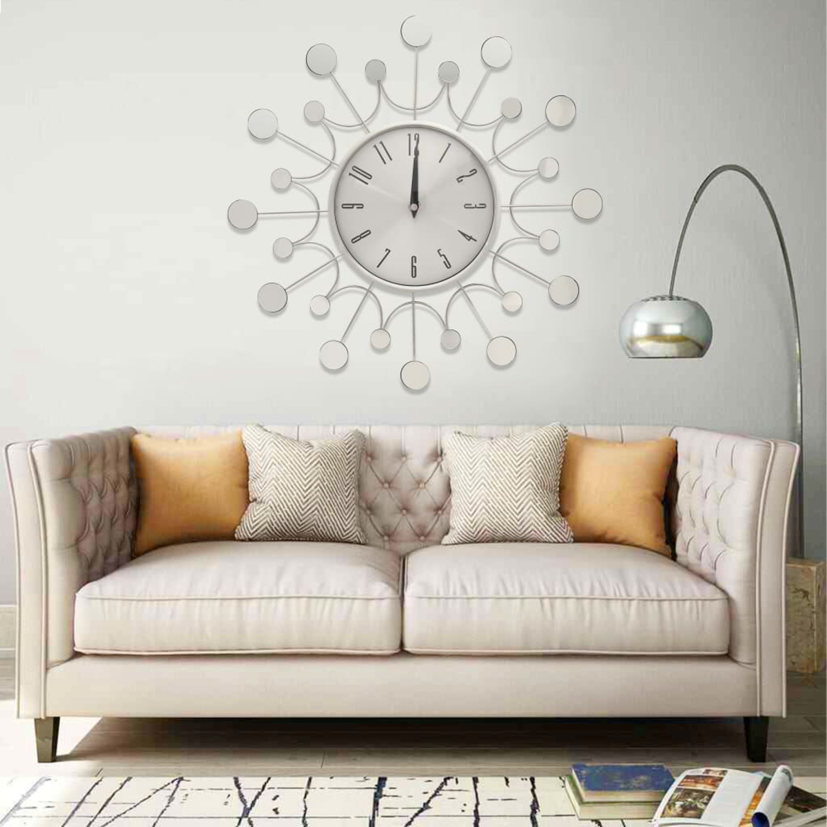 Ein modernes Wohnzimmer mit einer silbernen Uhr, einem weißen Sofa mit Kissen, einer Stehlampe und einem gemusterten Teppich.