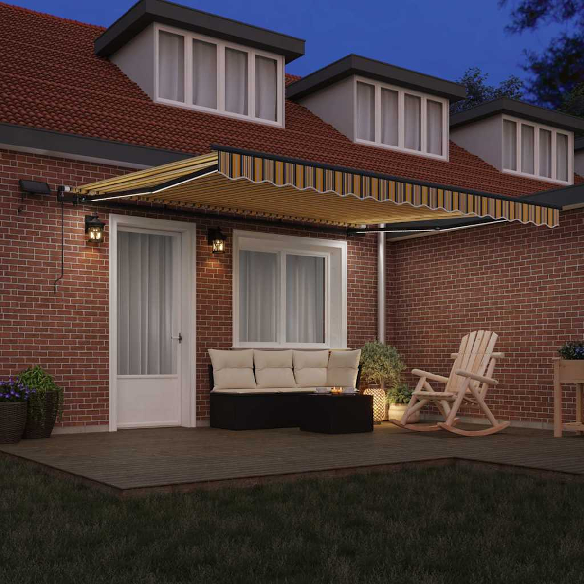 Ein Haus mit offener Markise, Terrasse mit Möbeln und roter Backsteinmauer. Der Himmel ist dunkelblau.