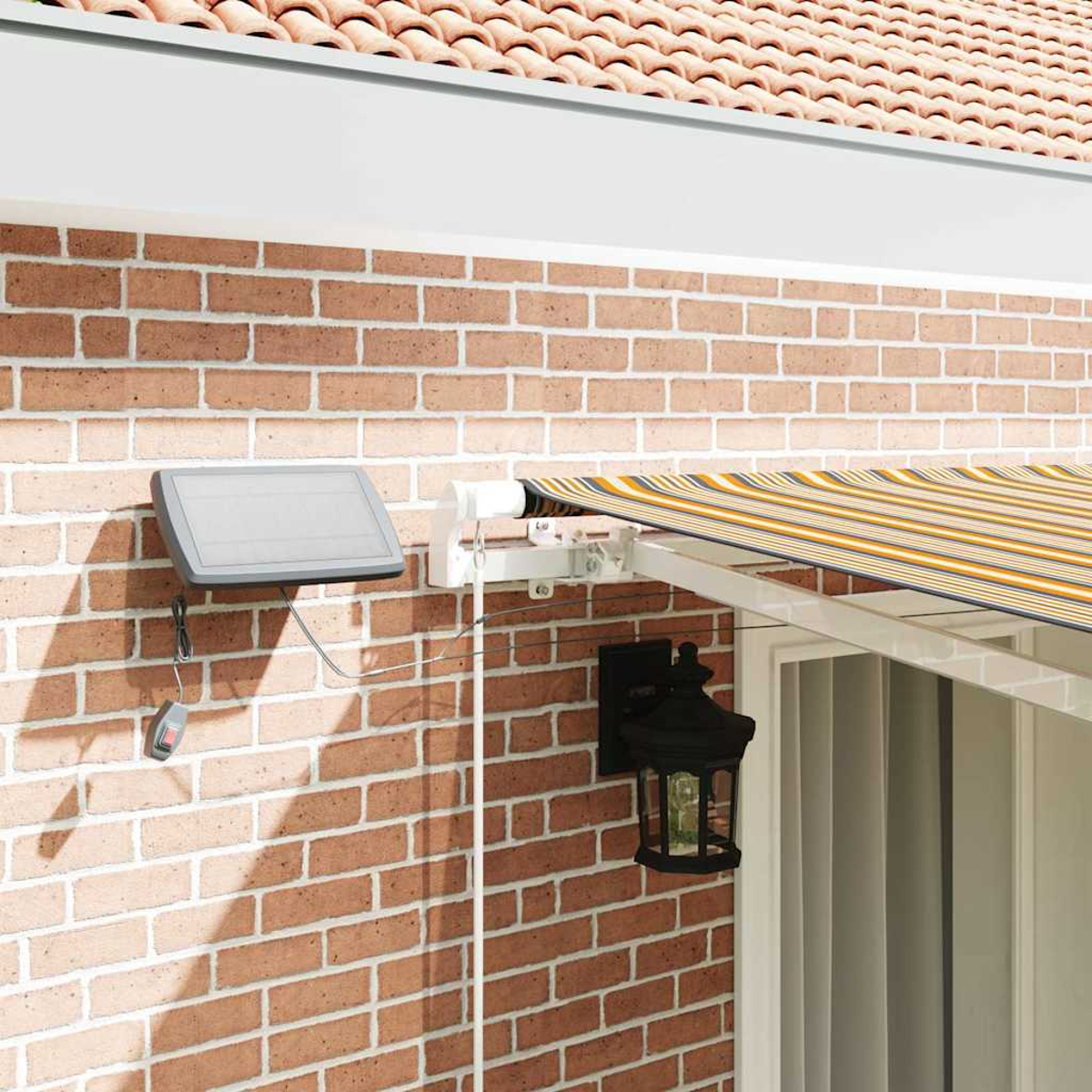 Ziegelmauer mit gestreifter Markise, Solarpanel und schwarzer Laterne. Die Markise ist gelb, blau und weiß gestreift.