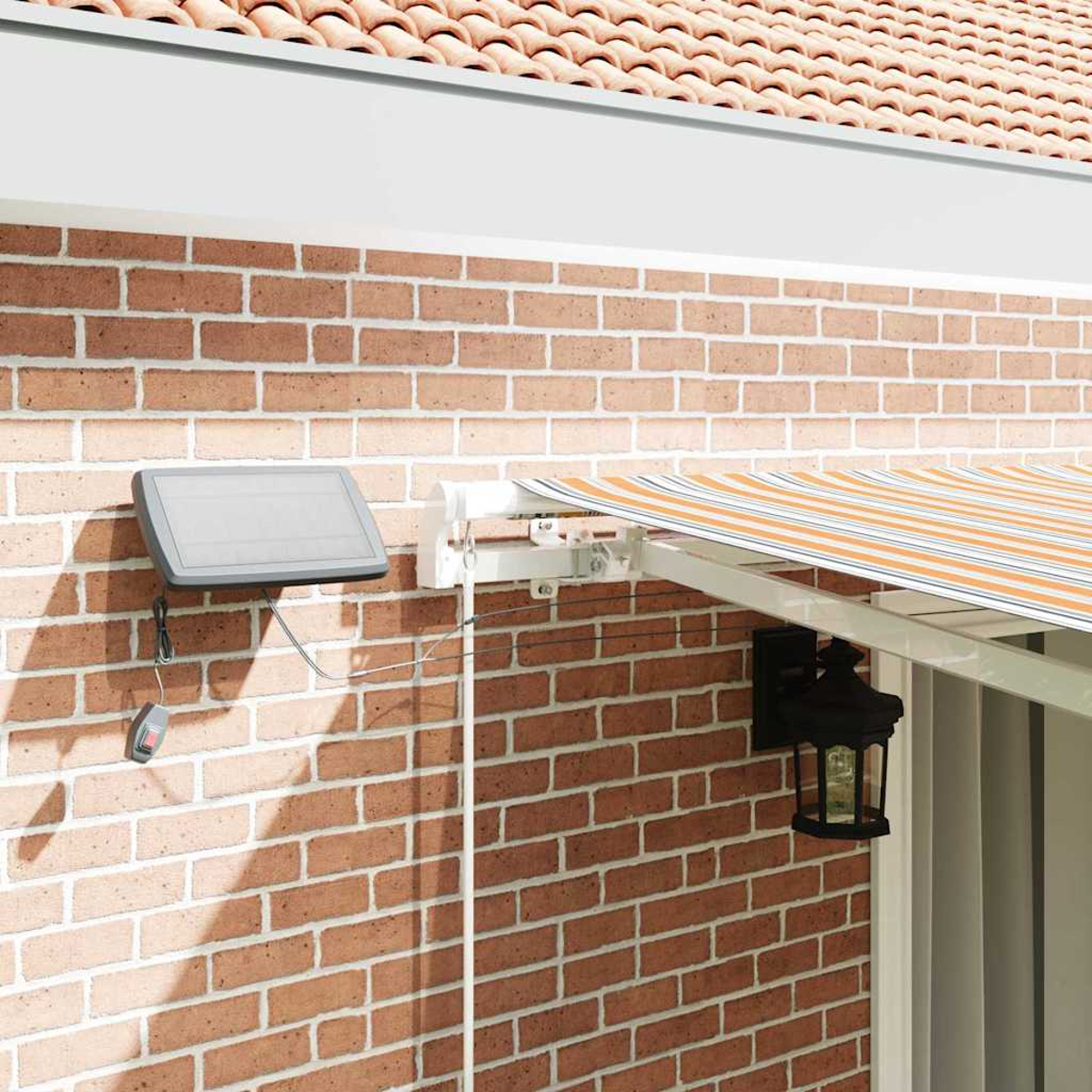 Ziegelmauer mit Markise. Links ein Solarpanel. Die Markise hat orange und weiße Streifen. Rechts eine Lampe.