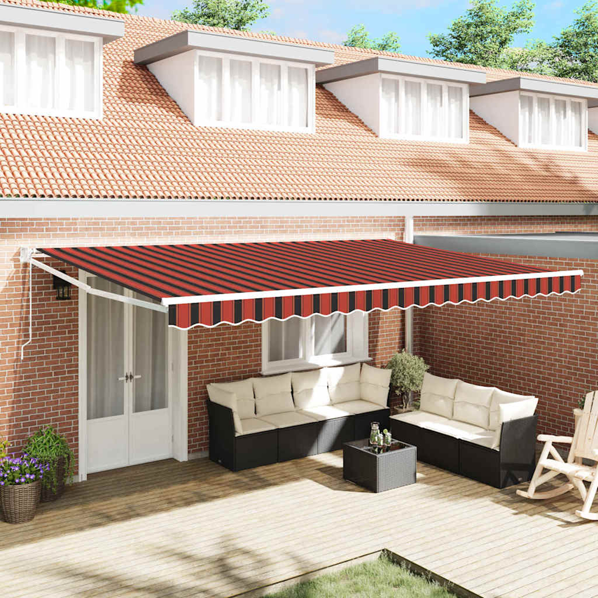 Ein rot-schwarz gestreifter Markise bedeckt eine Terrasse mit Sofa, Tisch und Schaukelstuhl. Eine Backsteinmauer und ein Haus sind im Hintergrund.