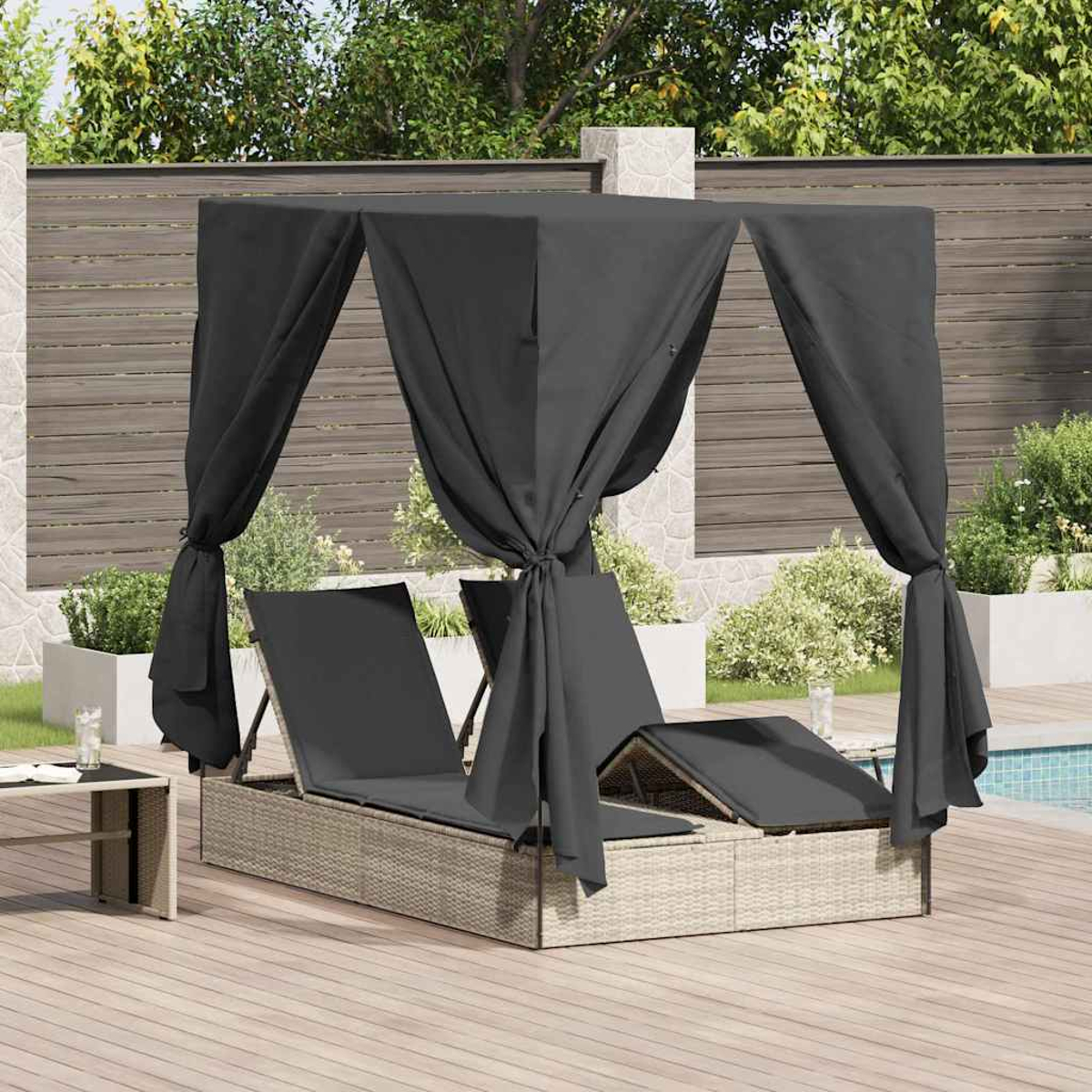Outdoor-Tagesbett mit schwarzem Baldachin und Kissen auf einer Holzterrasse. Hintergrund: Zaun, Grün und Pool.