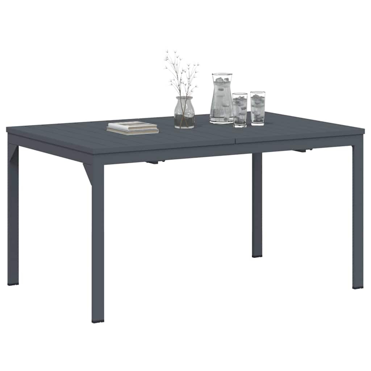 Mesa gris con objetos: libro, jarrón con flores, jarra y dos vasos. El fondo es blanco.
