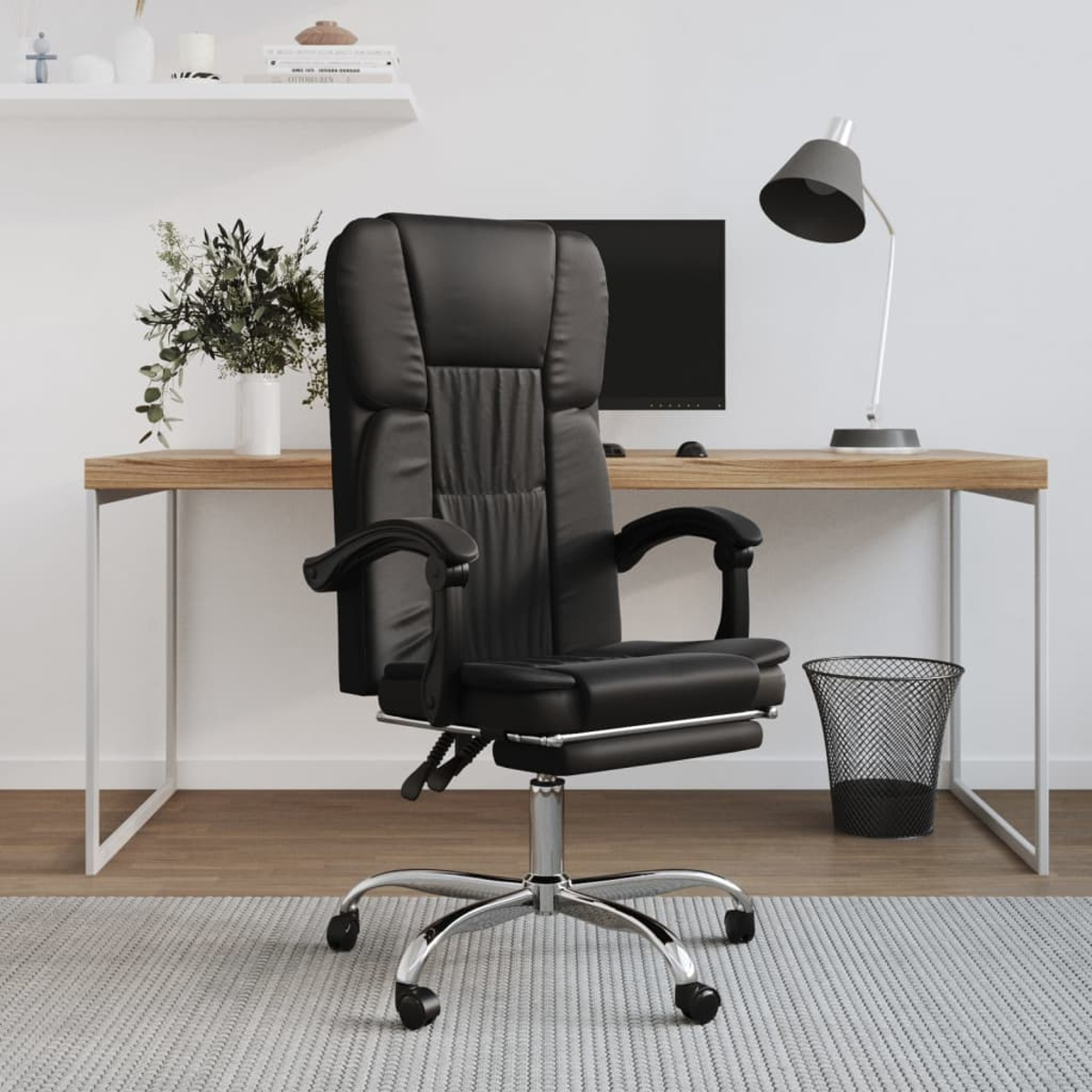 Ein schwarzer Bürostuhl steht vor einem Holztisch. Eine Lampe, ein Monitor und ein Mülleimer sind ebenfalls zu sehen.