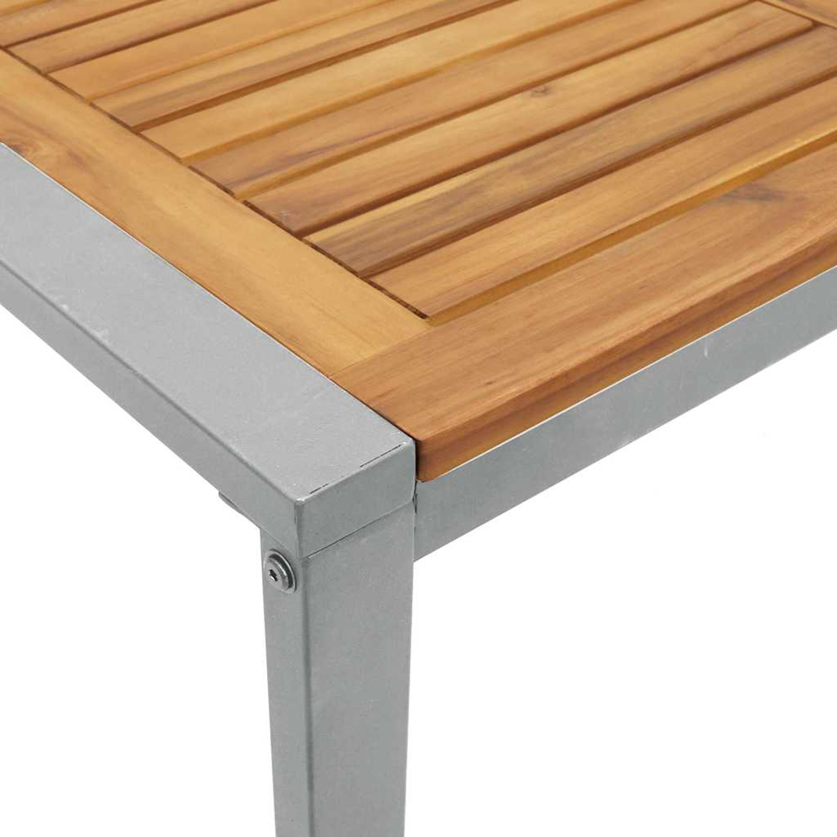 Nahaufnahme einer Tischecke. Holzplatte mit horizontalen Lamellen, umrahmt von grauen Metallkanten und -beinen. Heller Hintergrund.