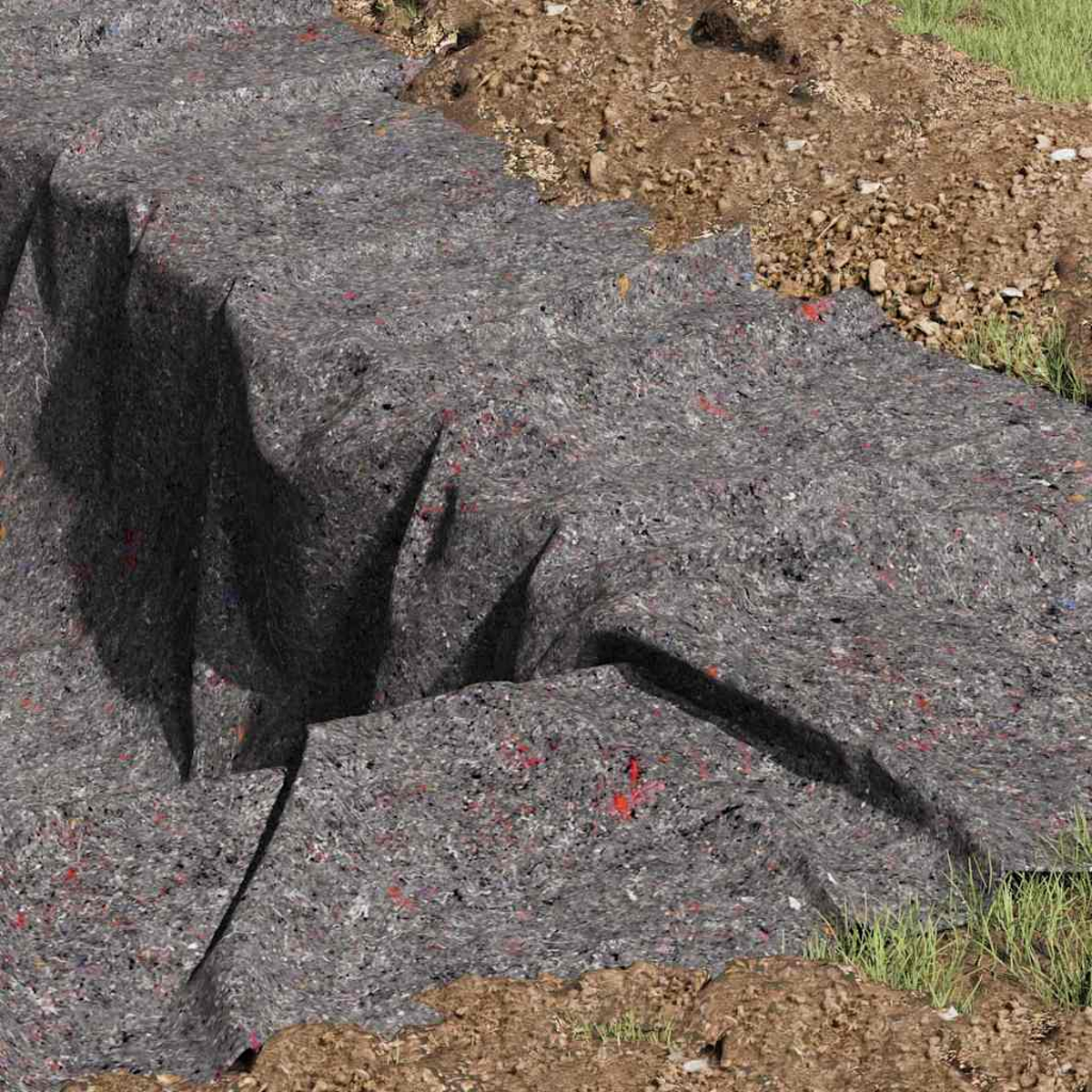 Grauer Stoff bedeckt einen Graben, mit roten und anderen farbigen Flecken. Erde und Gras umgeben ihn.
