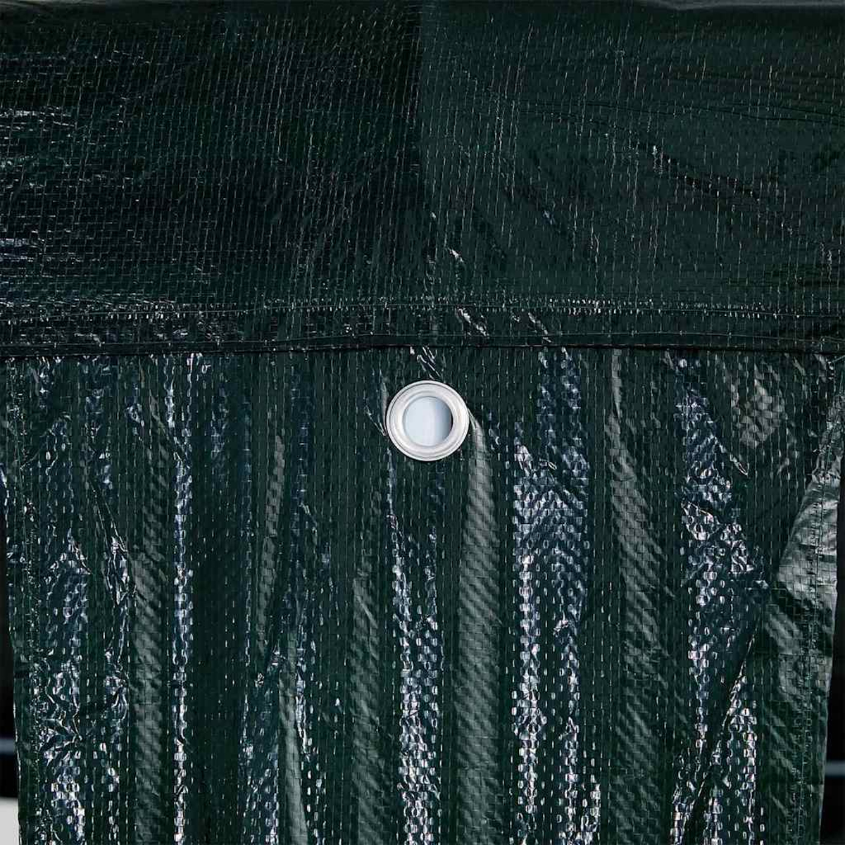 Primo piano di un telo verde scuro, ruvido, con un occhiello argentato, che mostra il suo materiale impermeabile.