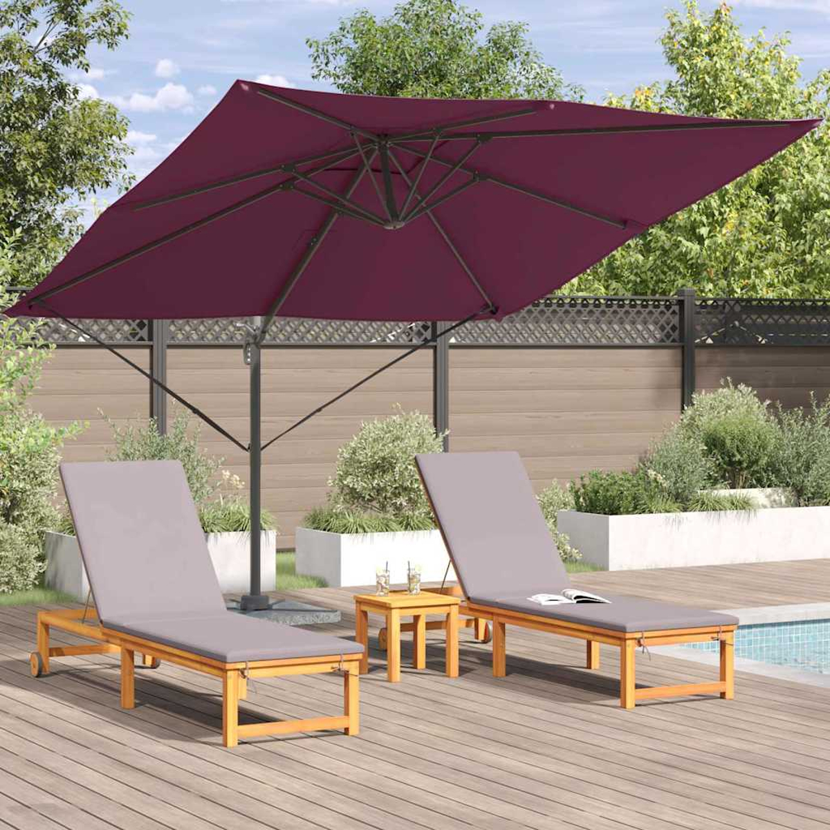 Un ombrellone bordeaux ombreggia due lettini di legno e un tavolino su un ponte di legno. Sullo sfondo una piscina e una recinzione.