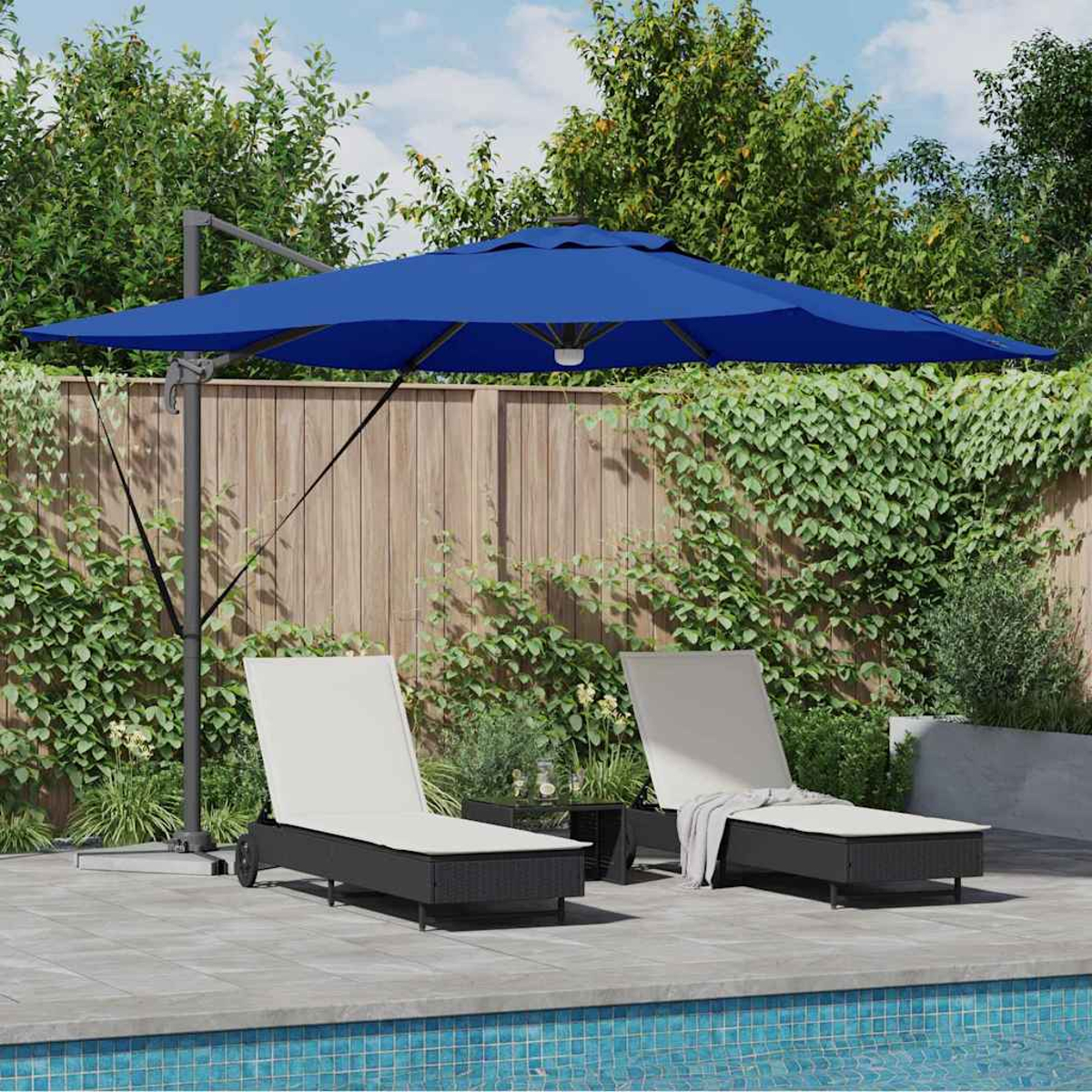 Scena all'aperto con ombrellone blu, due sedie a sdraio e una piscina. Fogliame verde e recinzione in legno sullo sfondo.