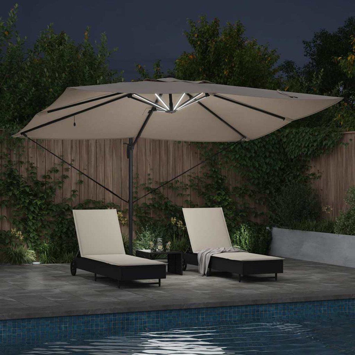 Scena notturna con patio, due sedie a sdraio sotto un ombrellone illuminato vicino a una piscina, alberi sullo sfondo e una staccionata di legno.