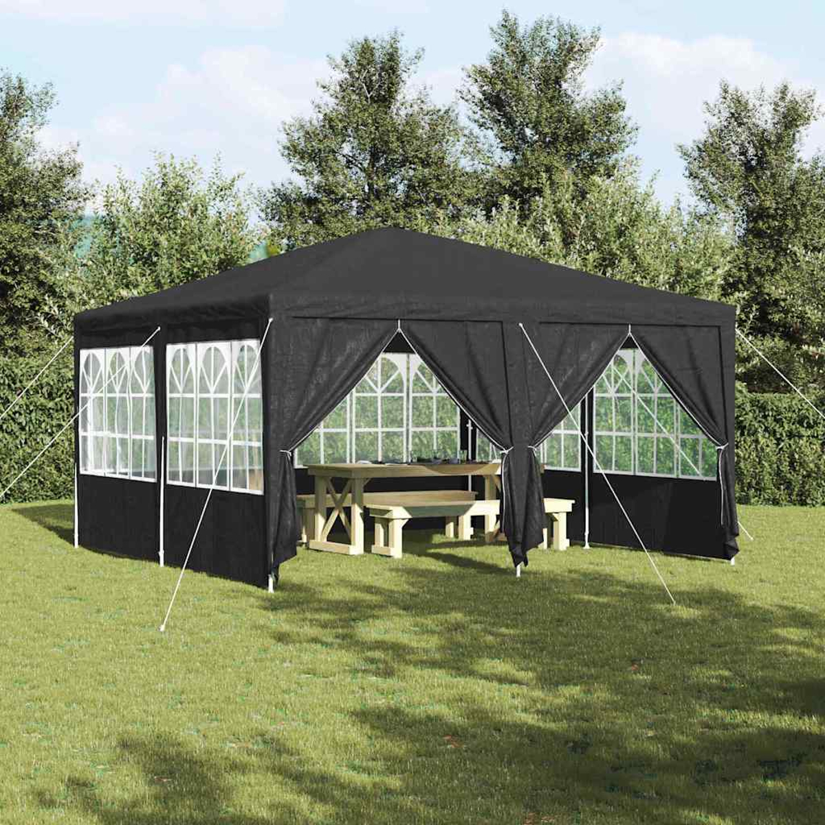 Ein schwarzer Pavillon mit weiß gerahmten Fenstern und einem Picknicktisch aus Holz steht auf grünem Gras. Bäume sind im Hintergrund.