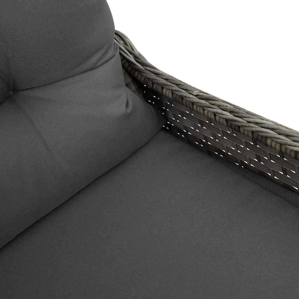 Nahaufnahme eines grauen Sofas im Freien. Ein graues Kissen und eine Armlehne aus geflochtenem Rattan sind zu sehen.