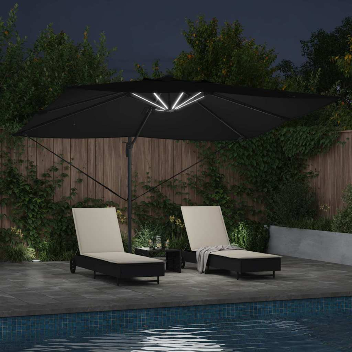 Scena notturna con due sedie a sdraio sotto un ombrello nero illuminato. Un tavolino è tra di loro. Una piscina è in primo piano.