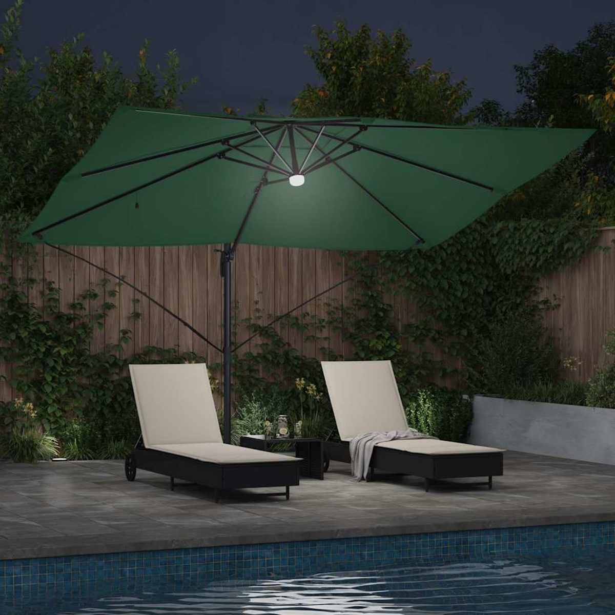 Scena notturna: patio con piscina, due sedie a sdraio, ombrellone verde e tavolo. Piante e recinzione in legno sullo sfondo.