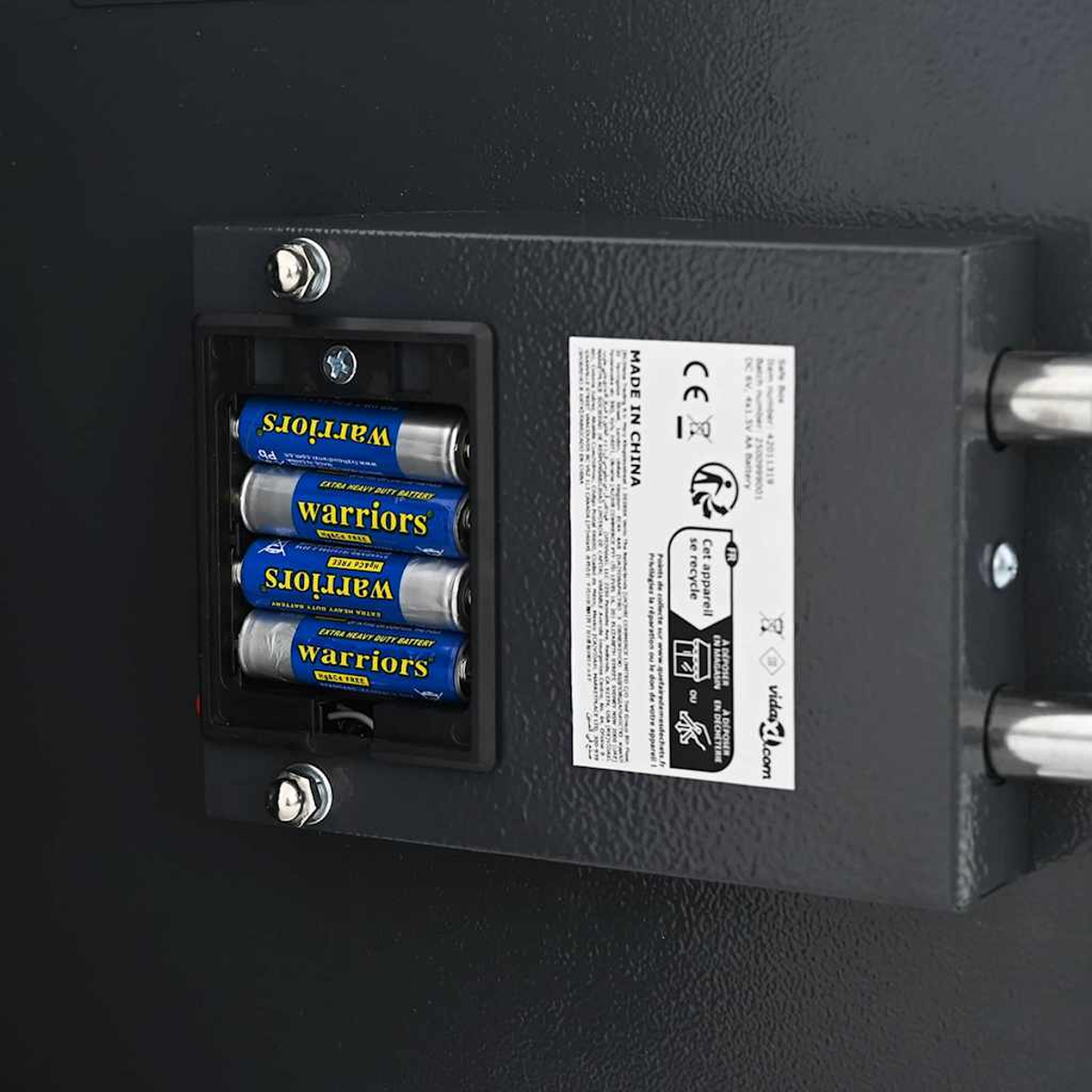 Vier blaue Batterien mit der Aufschrift 'warriors' in einem schwarzen Fach. Auf der rechten Seite befindet sich ein Etikett, und Bolzen sichern es.