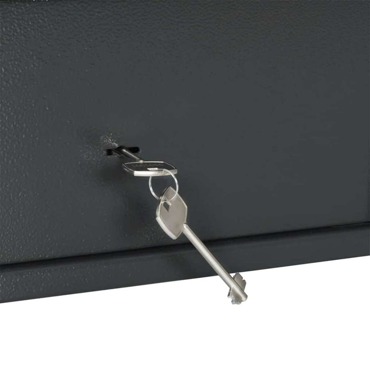 Primo piano di una superficie metallica grigio scuro con una chiave inserita. Una chiave d'argento pende dalla serratura.