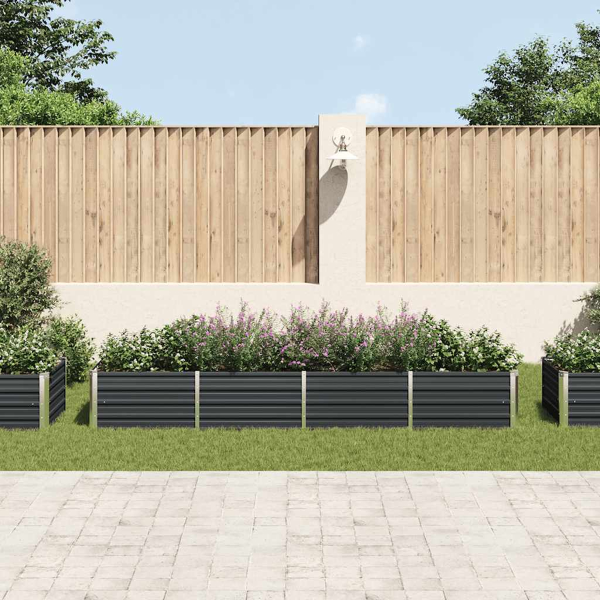 Eine Gartenszene mit grauen Pflanzkästen, die mit Pflanzen gefüllt sind und auf Gras stehen. Im Hintergrund ein Holzzaun und eine Laterne.