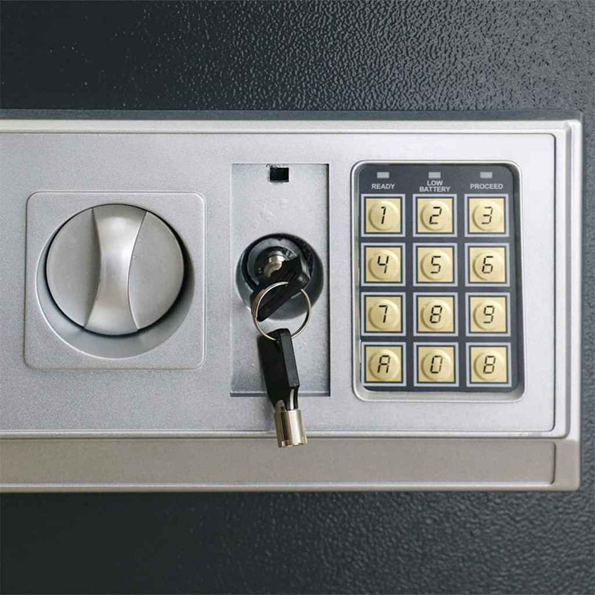 Primo piano del pannello di controllo di una cassaforte. Ha un quadrante, una serratura con una chiave e una tastiera con numeri e pulsanti funzione.