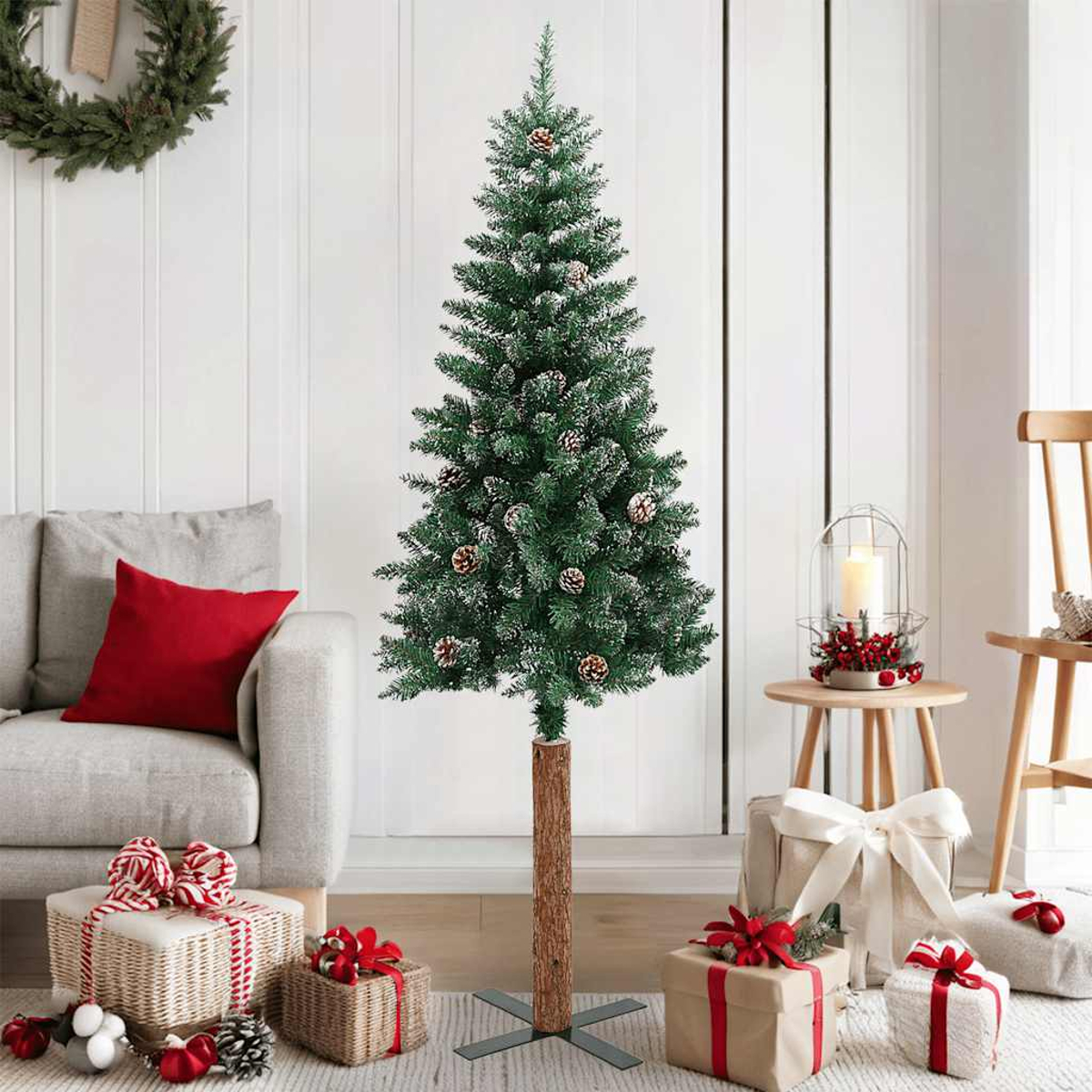 Ein Weihnachtsbaum steht in einem Raum mit Geschenken, einem Kranz und einem Sofa. Die Geschenke sind mit Bändern verpackt, was eine festliche Atmosphäre schafft.