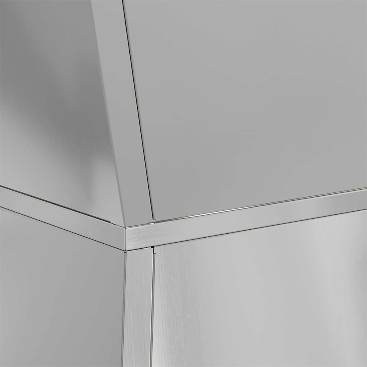 Primo piano di una struttura in acciaio inossidabile. L'immagine mostra l'angolo di un oggetto metallico con superfici spazzolate e lucide.