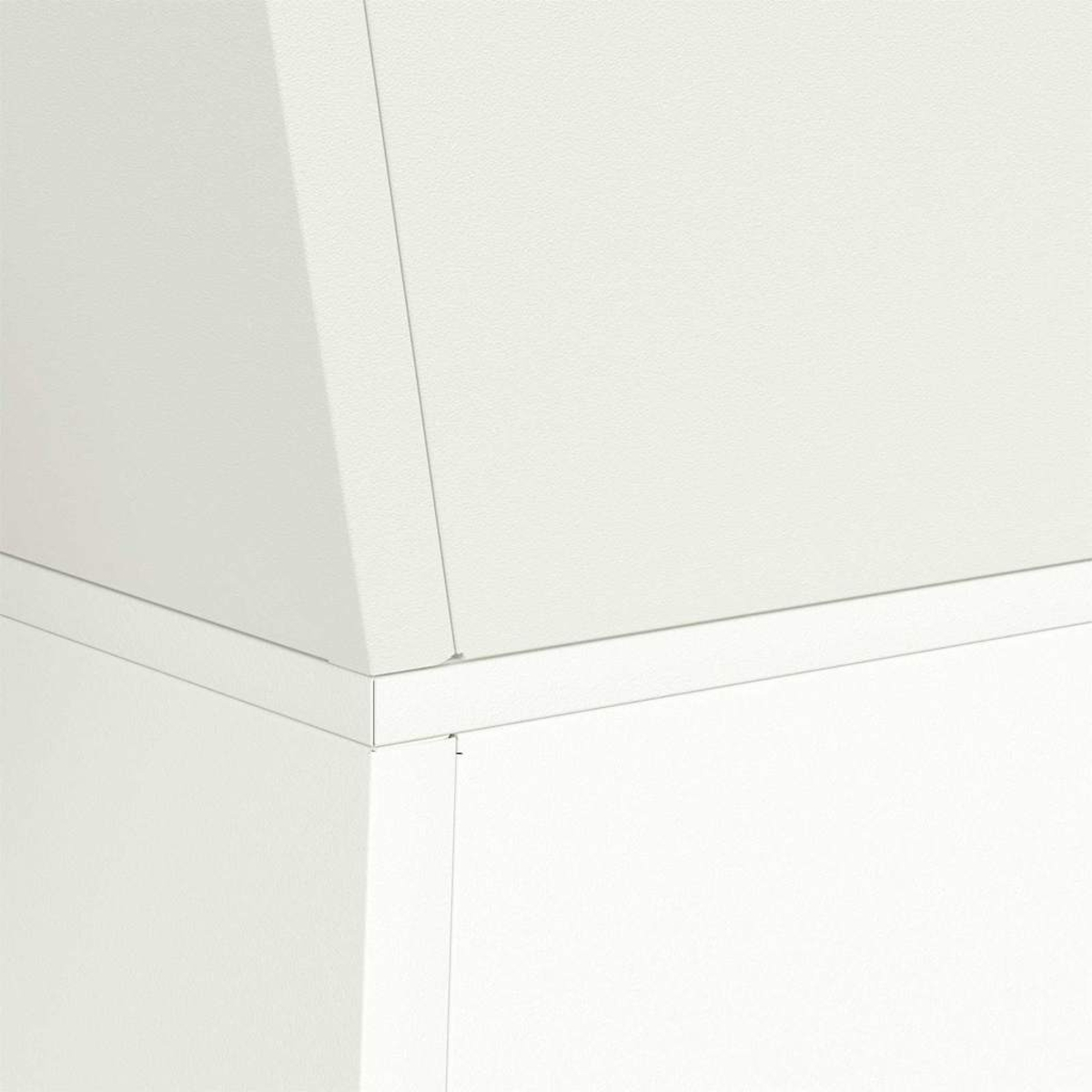 Primo piano di elementi architettonici bianchi. Un angolo mostra un angolo acuto con una linea verticale e una superficie strutturata.