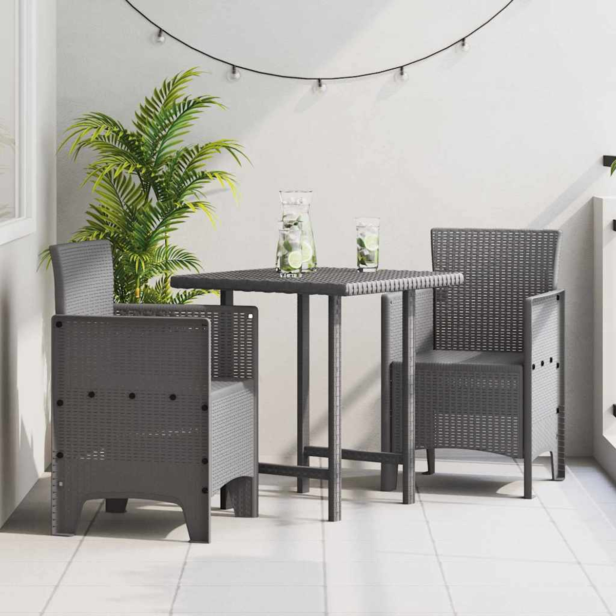Graues Terrassenset mit zwei Stühlen und einem Tisch. Auf dem Tisch stehen eine Pflanze und Getränke. Lichterketten hängen darüber.