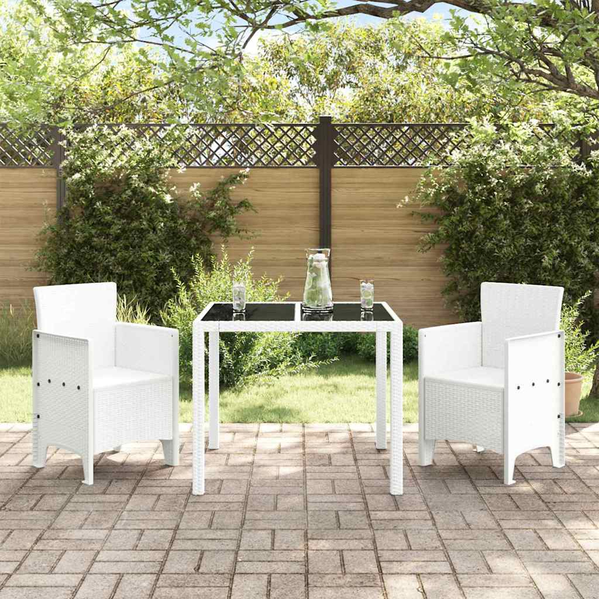 Ein weißes Terrassenset mit zwei Stühlen und einem Tisch. Auf dem Tisch stehen ein Krug und Gläser. Im Hintergrund grünes Gras und ein Zaun.