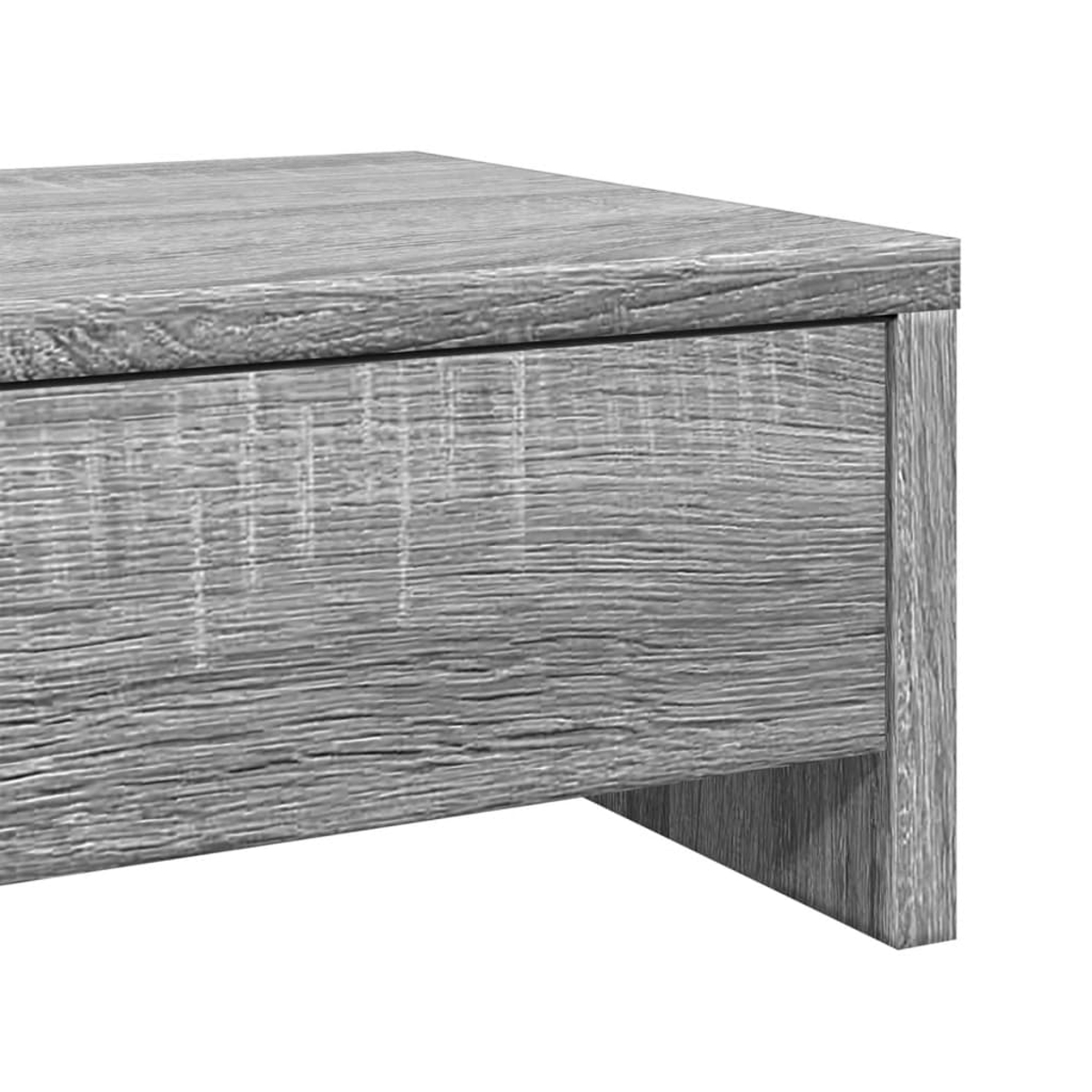 Nahaufnahme eines grauen Holztisches. Der Tisch hat eine Schublade und ein Bein. Die Holzmaserung ist sichtbar.