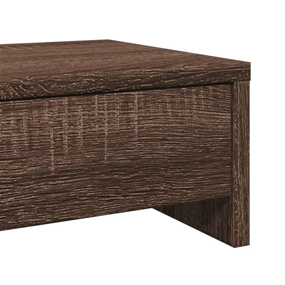 Nahaufnahme einer Holztischecke. Das Holz ist braun mit einer körnigen Textur. Der Tisch hat ein schlichtes, modernes Design.
