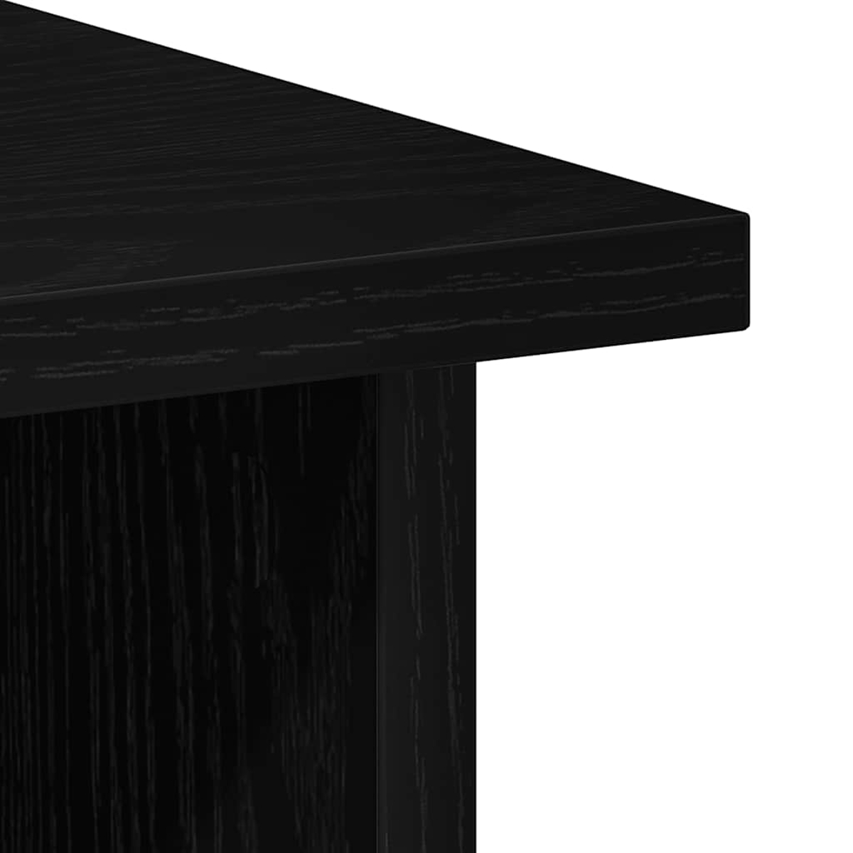 Nahaufnahme einer Ecke eines schwarzen Holztisches. Die Holzmaserung ist sichtbar. Der Hintergrund ist weiß.
