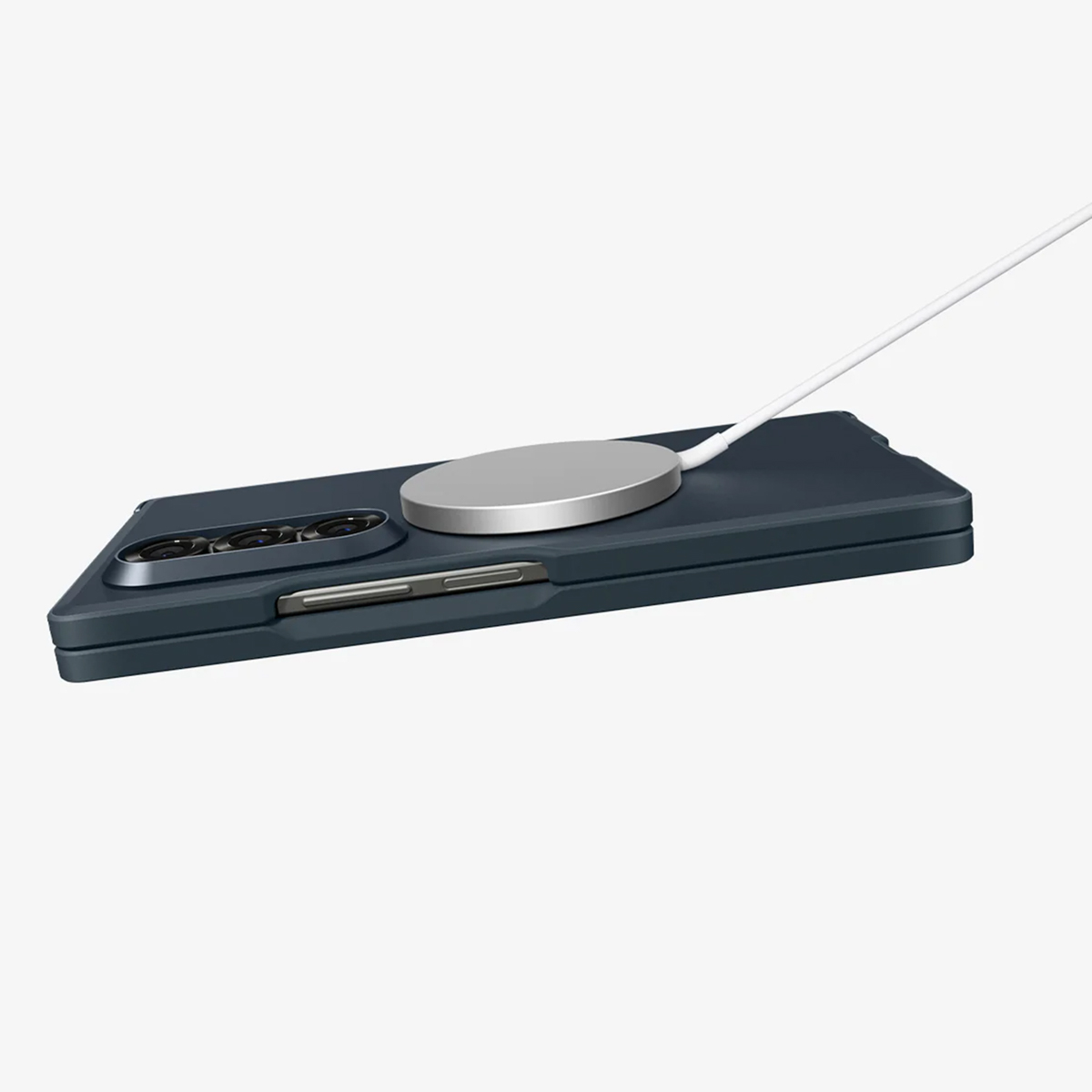Un téléphone bleu foncé avec un chargeur sans fil argenté attaché via un câble blanc. Le téléphone est sur fond blanc.