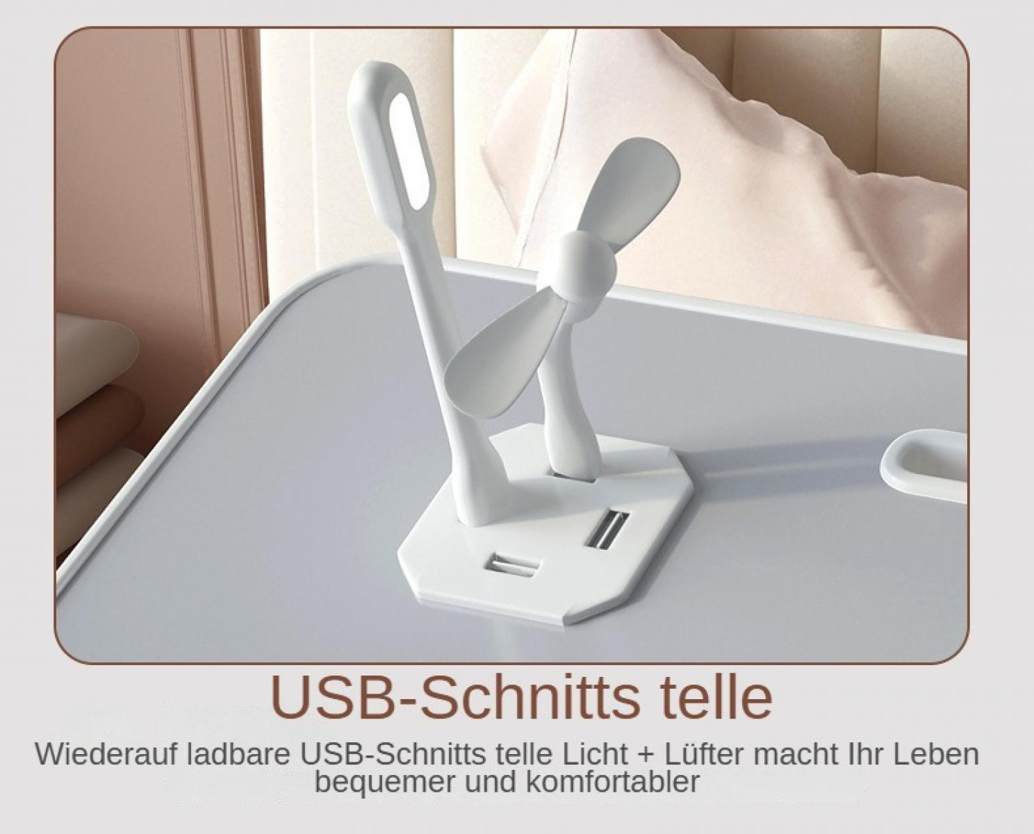 Eine weiße USB-Licht- und Lüfterkombination auf einer grauen Oberfläche. Ein Bett und eine Wand sind im Hintergrund.