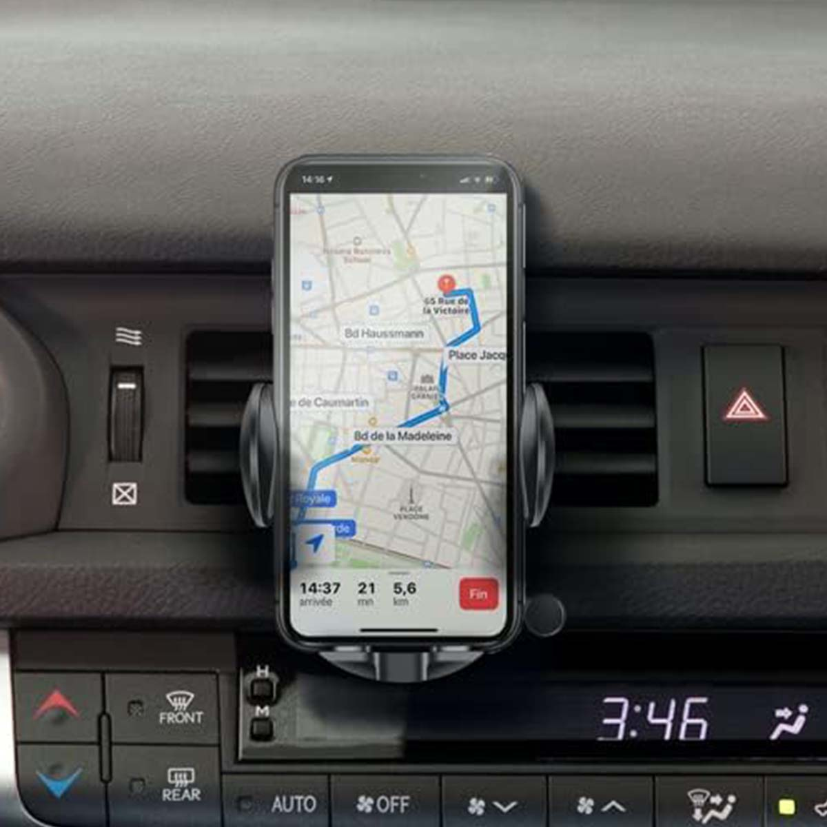 Un smartphone que muestra una aplicación de mapas está montado en el salpicadero de un coche. El mapa muestra una ruta con un punto final.